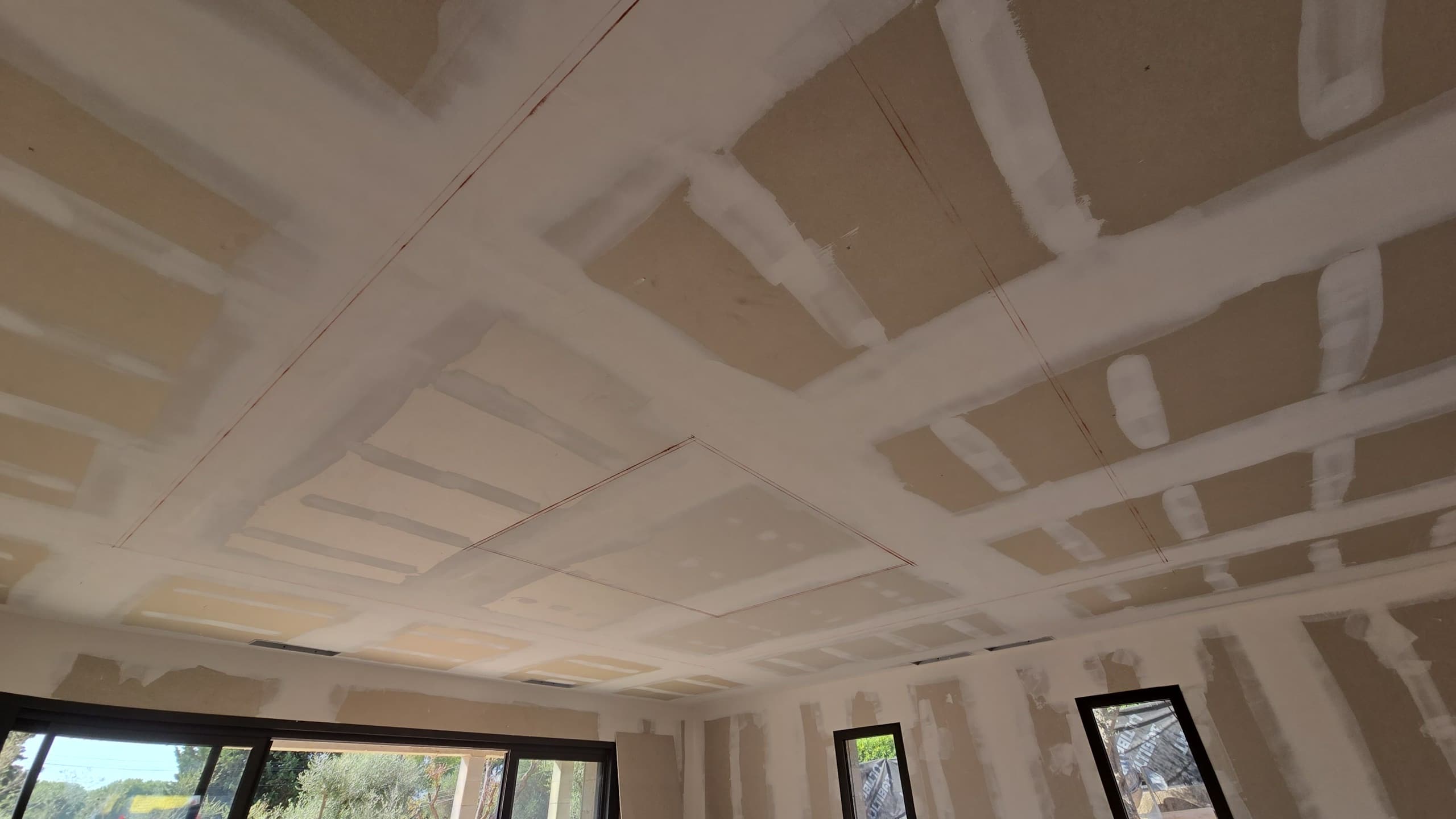Traçage du plafond avant découpe pour l’installation d’un bandeau LED encastré dans un salon